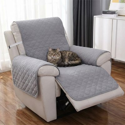 Un chat à poil long est couché sur une protection canapé chat du fauteuil inclinable beige 