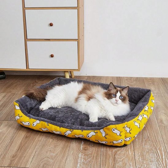 Un chat  allongé confortablement dans un panier chat rectangulaire et moelleux 