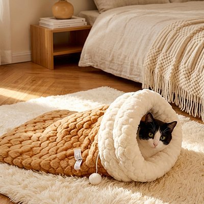 Chat allongé confortablement dans un lit chaton posé sur un tapis