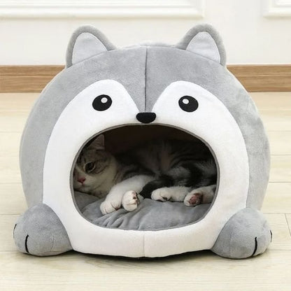 Chat tigré gris et blanc allongé confortablement dans un panier pour chat en peluche grise