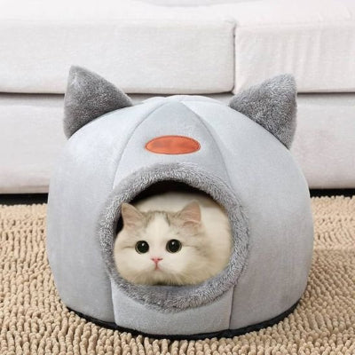 Chat blanc installé dans panier chat gris en forme d'igloo avec des oreilles de chat décoratives