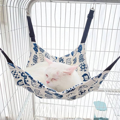 Chat détendu allongé sur un hamac pour chat dans un intérieur calme et lumineux.