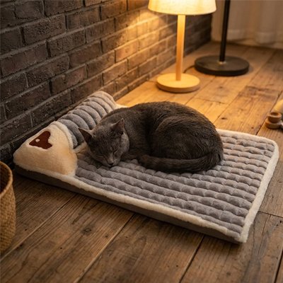 Chat gris dormant sur un lit pour chat  dans un intérieur chaleureux