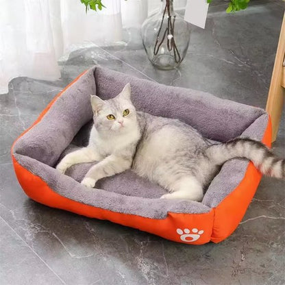 Chat gris et blanc allongé confortablement dans un panier chat gris avec bordure orange