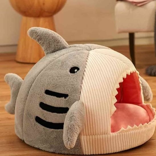 Chat panier en forme de requin de couleur gris posé sur plancher en bois