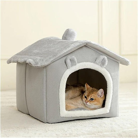 Chat roux couché à l'intérieur d'une niche pour chat en peluche grise