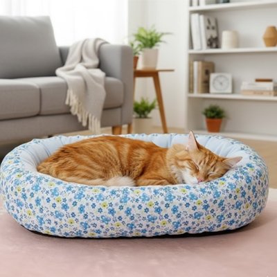 Chat roux endormi paisiblement dans un coussin pour chat à motif floral