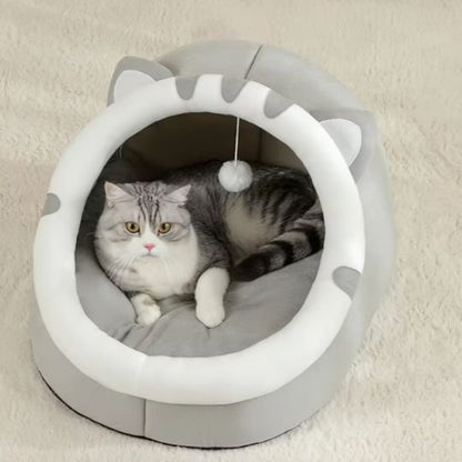 Chat tigré allongé paisiblement à l'intérieur du lit chaton de couleur gris