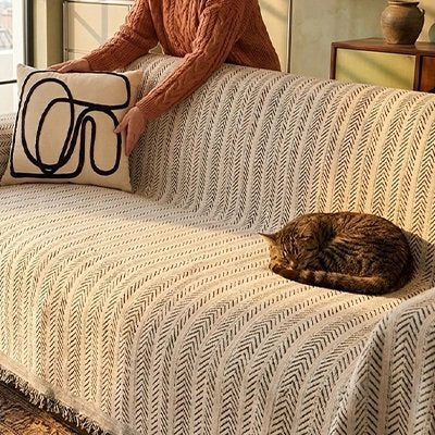 Chat tigré endormi sur une hausse canapé chat de couleur blanche