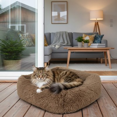 Chat tigré se repose dans un lit pour chat rond et duveteux de couleur gris marron