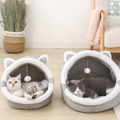 Deux paniers pour chat en forme de tête de chat  qui sont posés sur un plancher clair