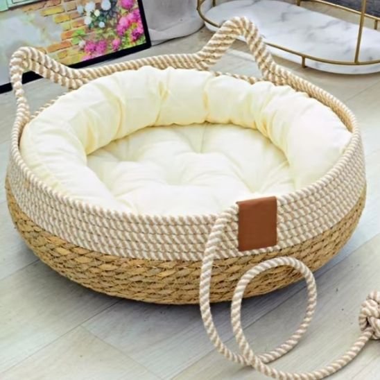 Lit pour chat de forme circulaire, élégant et de style bohème, posé sur un sol en bois clair.