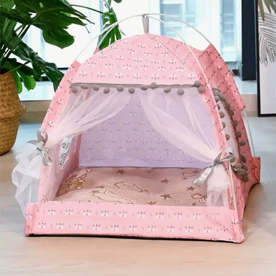 Niche pour chat en tissu rose à motifs graphiques discrets avec voilages blancs transparents