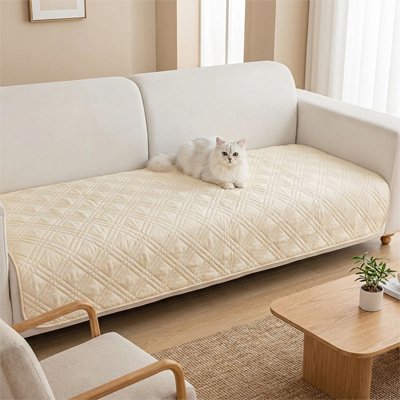 Protection canapé chat beige matelassé avec un chat blanc allongé dessus