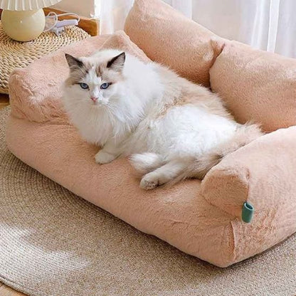 Un chat à poils longs et aux yeux bleus, allongé sur un panier pour chat de couleur pêche.