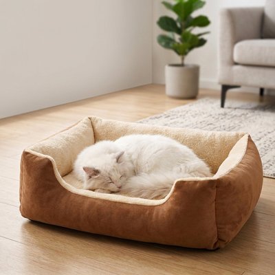 Un chat blanc dort paisiblement dans un panier chat rectangulaire marron et crème