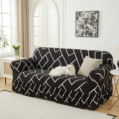 Un chat blanc est allongé sur un canapé doté d'un protege canape chat noire à motifs géométriques blancs