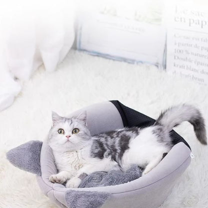 Un chat blanc et gris est couché dans un panier chat gris en tissu souple
