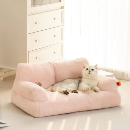 Un chat gris et blanc allongé sur un panier pour chat de couleur pêche.