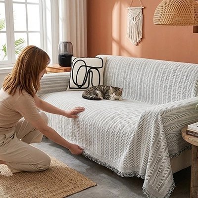 Une femme ajuste la hausse canapé chat de couleur blanche