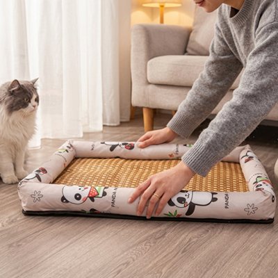 Une femme ajuste le tapis rafraichissant chat sur un plancher de bois tandis qu'un chat gris et blanc observe à côté