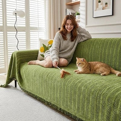 Une femme entrain de jouer avec son chat sur une hausse canapé chat verte